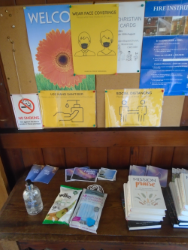 The welcome table now has Covid signs and sanitising gel