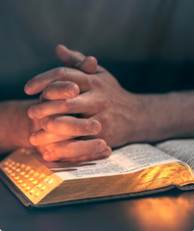 A person's hands folded over a book
AI-generated content may be incorrect.