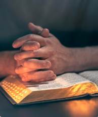 A person's hands folded over a book

AI-generated content may be incorrect.